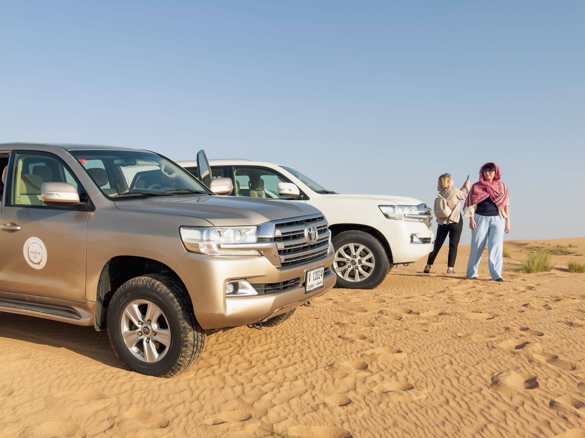 Four wheels Safari cars on stop between sand dunes