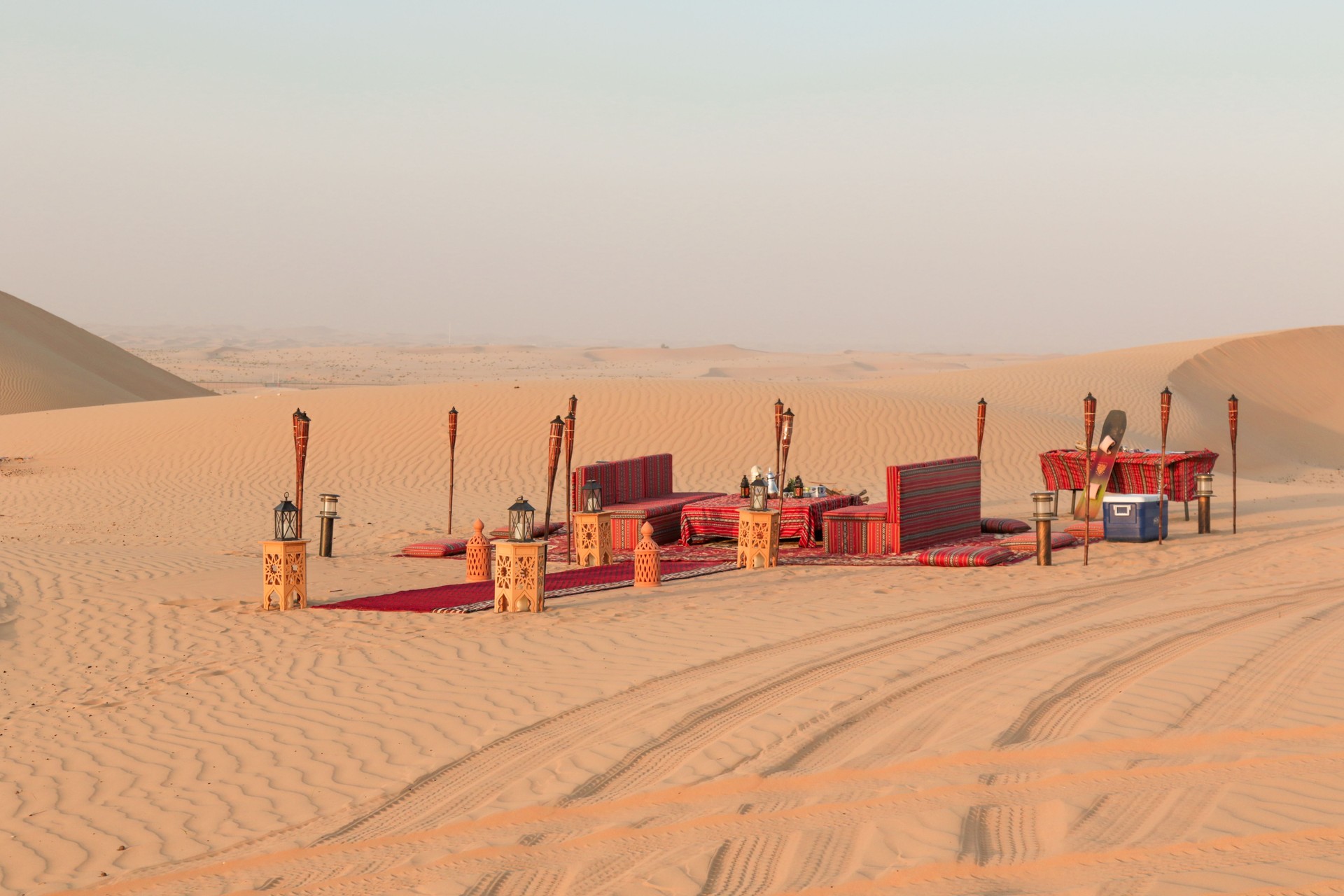 Desert dinner set up for sunset romantic meal at sand dunes with carpets and cushions