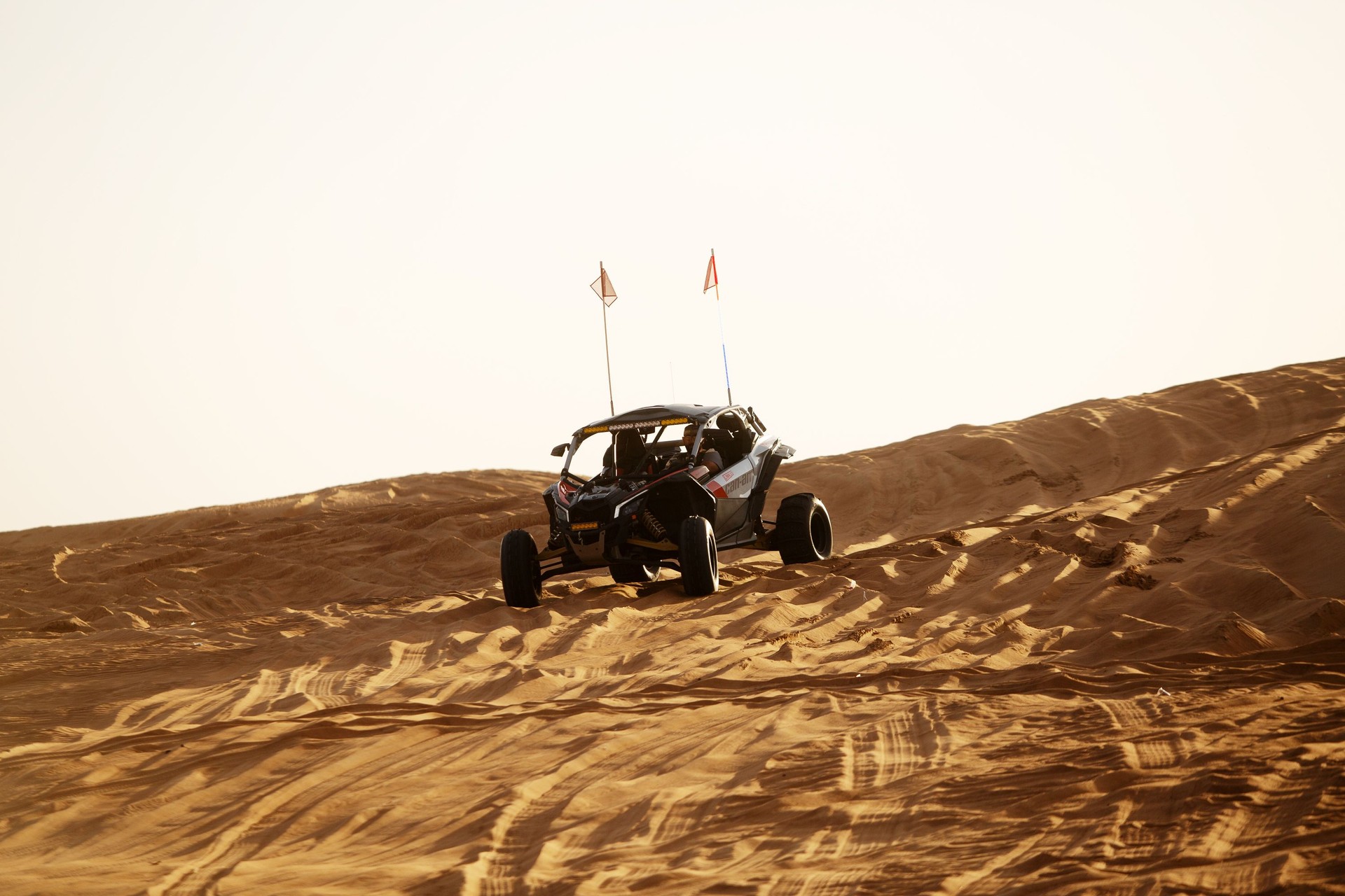 Dune Buggies being driven by tourists at aa Desert Safari park in the red sand dunes near Dubai